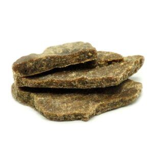 Imagen de trozos de Hash Dry Sift CBD de Natural Suit, mostrando su color dorado oscuro y su textura desmenuzable.